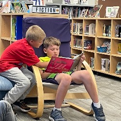 Two HPES students reading the same book.
